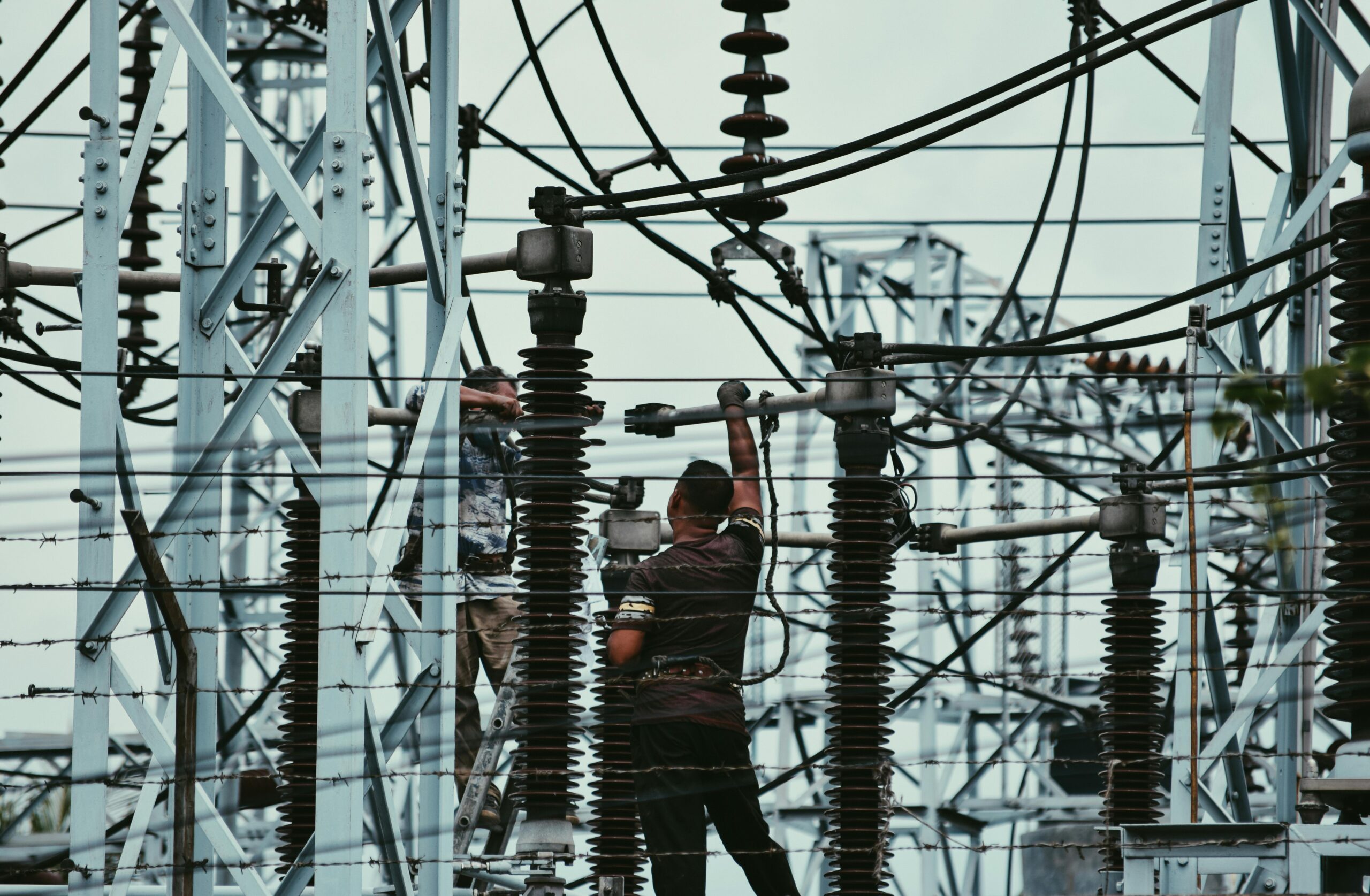 Electricians working on power lines, ensuring grid maintenance and safety.