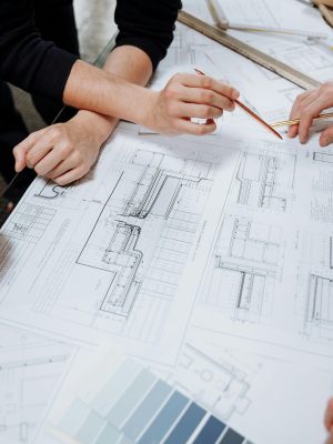 Architects discussing detailed blueprints and schematics at a table.